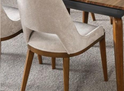 A laconic, modern chair with high wooden legs and upholstery in a pleasant, light cream color for the dining room.